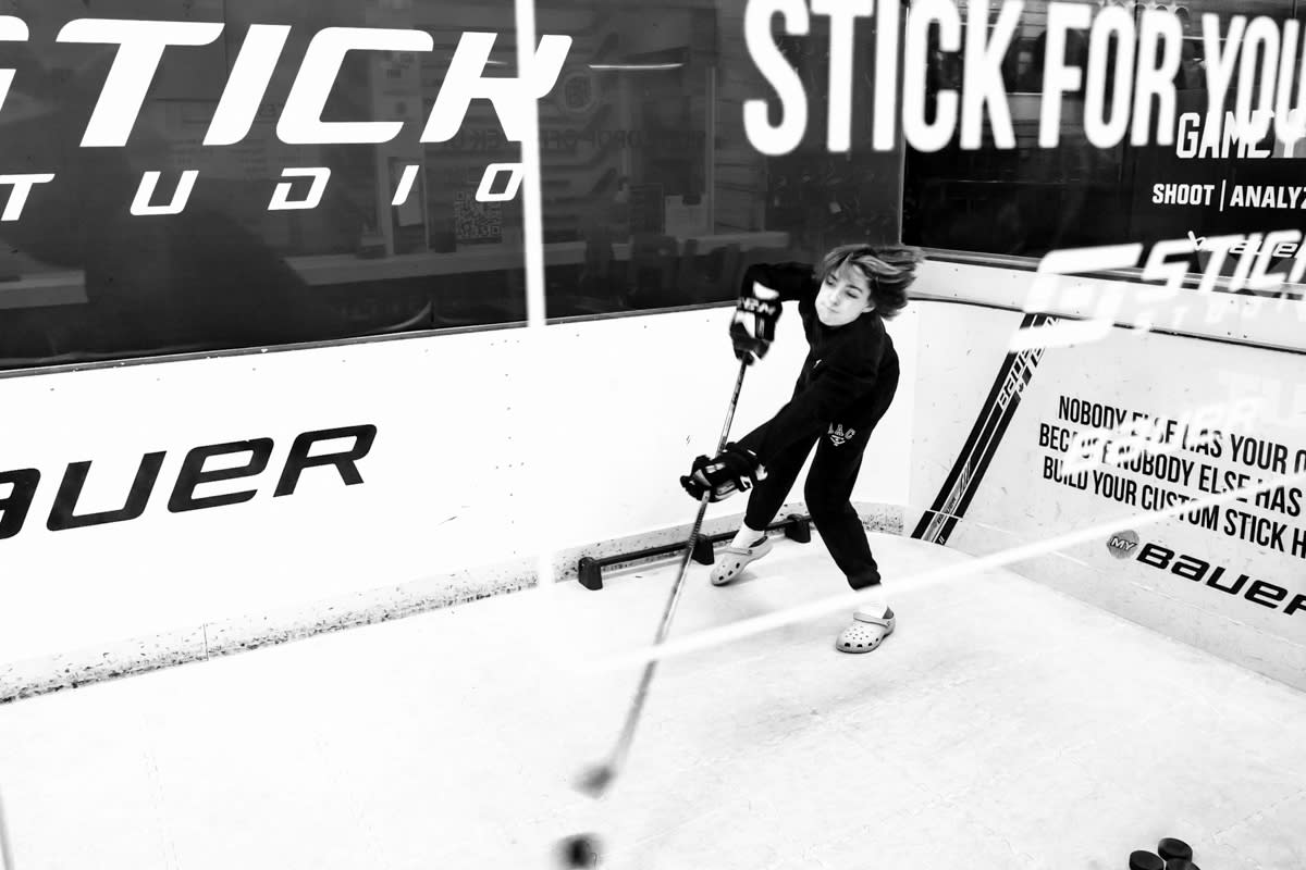 documentary image of teen boy practice-shooting at a stick shop in Calgary