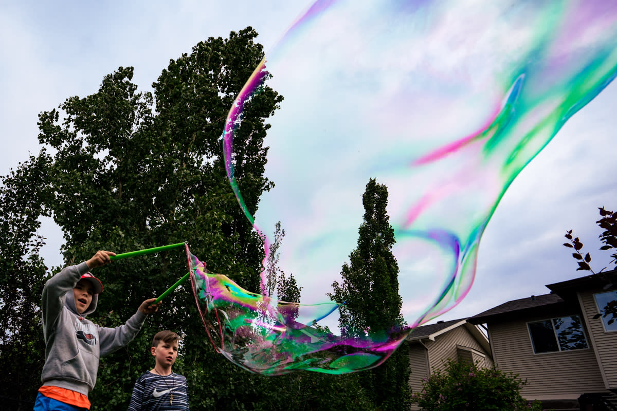 two boys making huge bubble documentary photograph Calgary