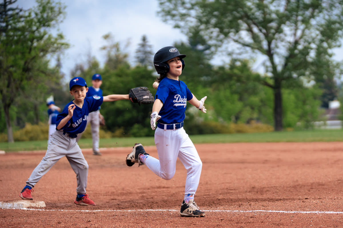 youth baseball boy clears third base going with confidence to home
