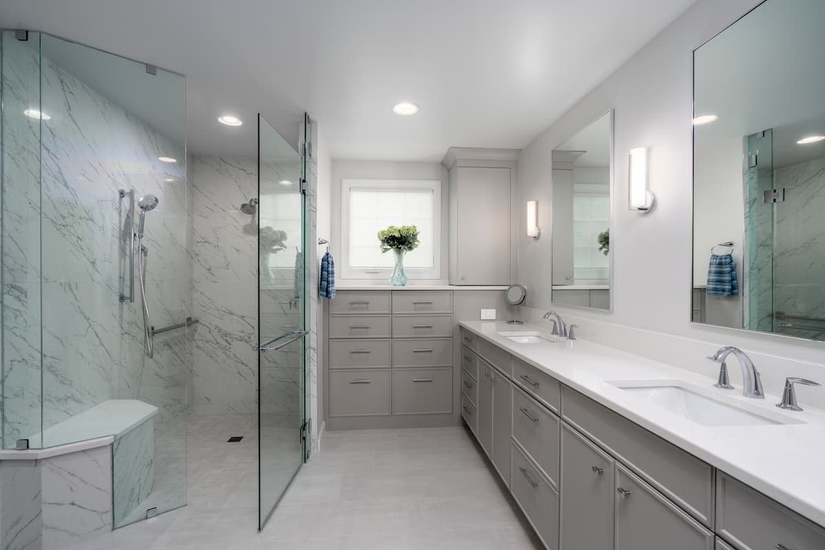 Primary bathroom remodel by Distinctive Design + Build + Remodel with abundant storage and a curbless shower.