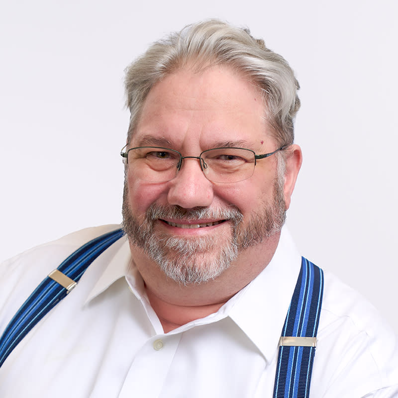 Corey Leon in a white shirt with blue suspenders