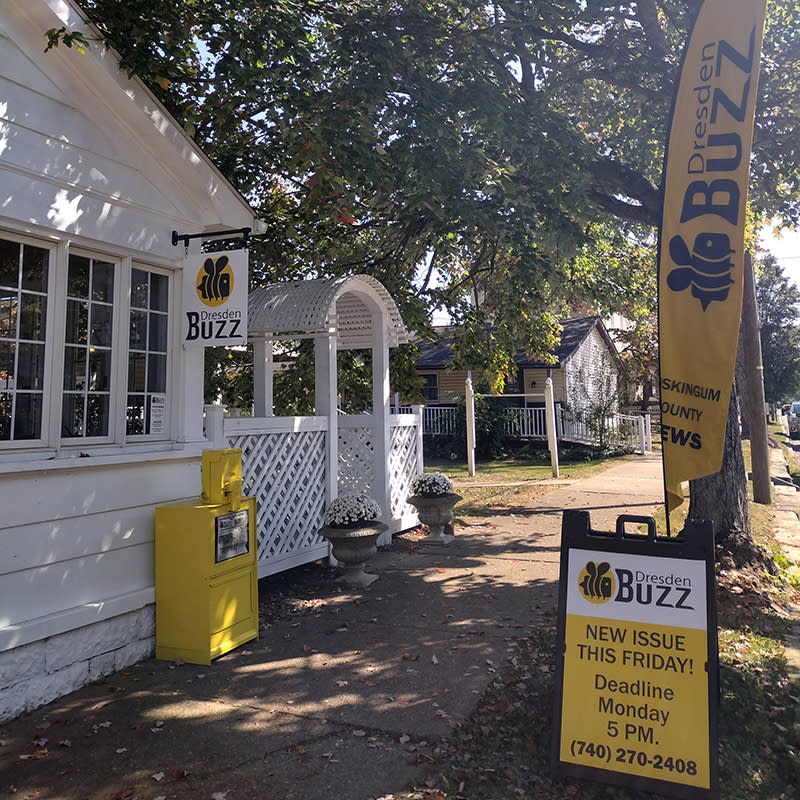 Front entrance of the Dresden Buzz office showing signage and a newspaper box.