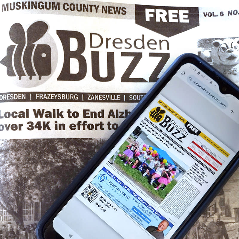 A picture of an issue of the Dresden Buzz and a cell phone with the digital edition displayed on the phone.