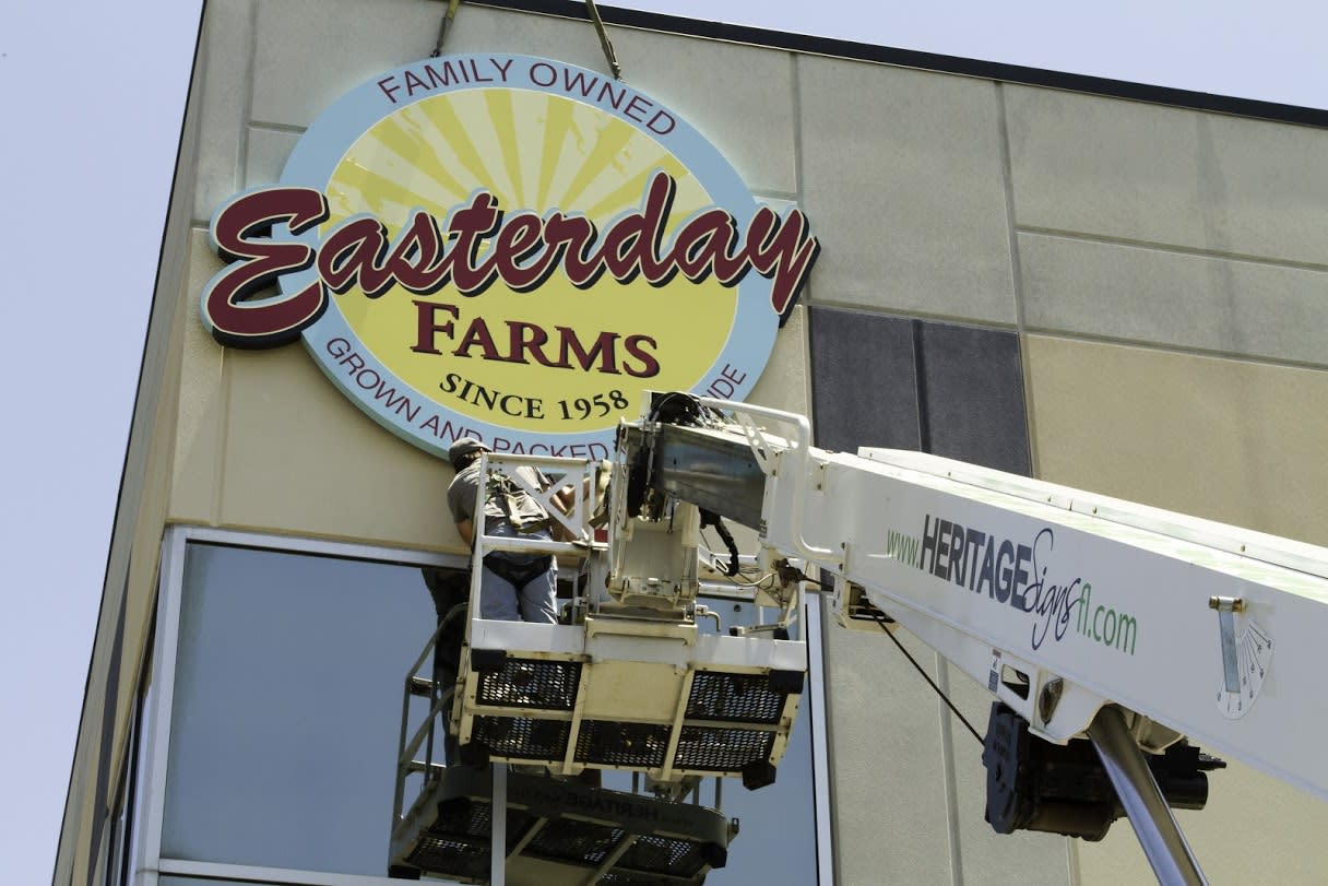 Sign Installers in bucket of crane truck
