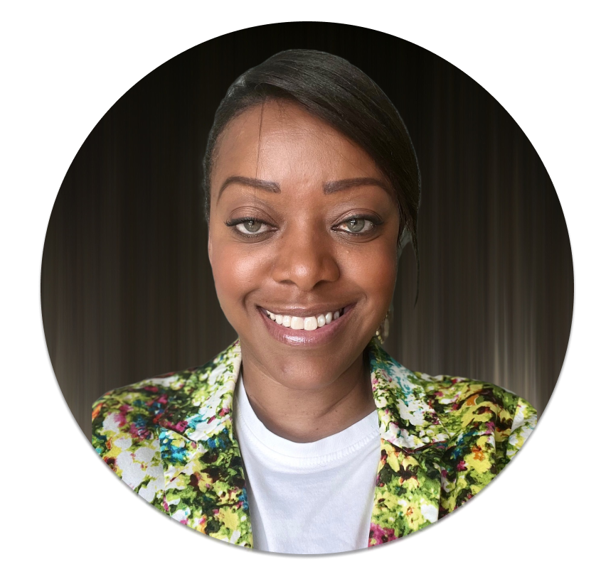 Hyacinth, a black woman with hair pinned back, smiling. Wearing a multicolored jacket and white tshirt