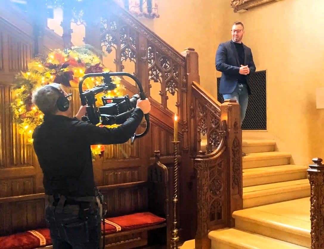 Camera operator filming a TV host inside the Paine Arts Center in Oshkosh, Wisconsin.