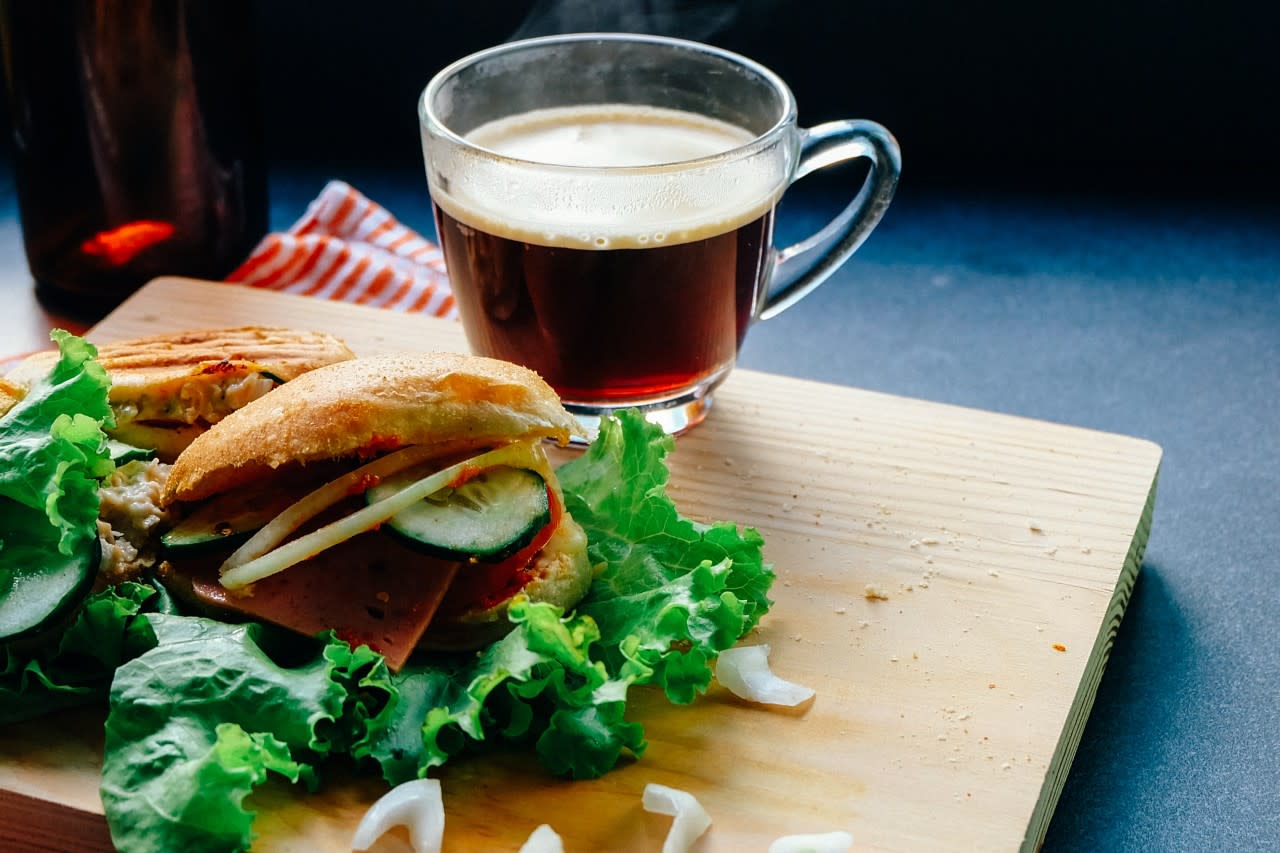 Photo of a sandwhich and a cup of tea or coffee