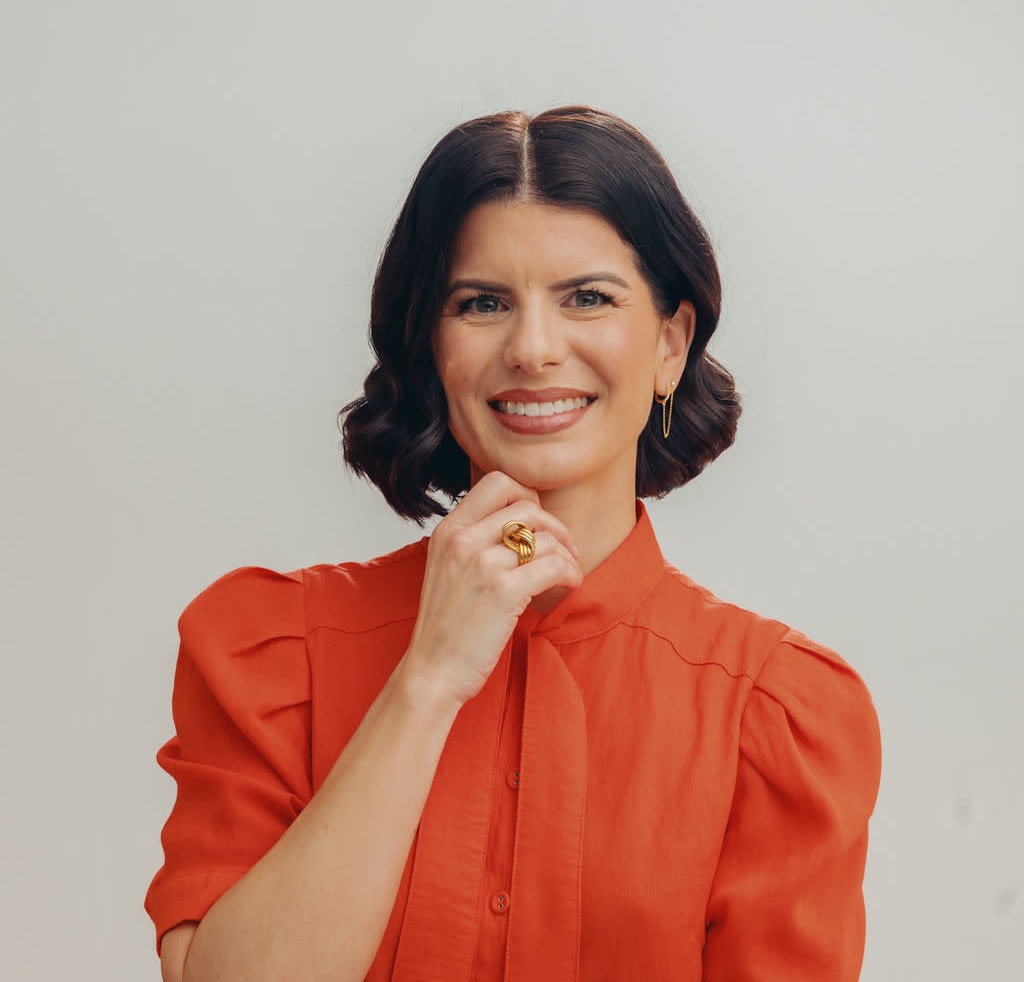 Margaux Joffe wears an orange blouse, smiling
