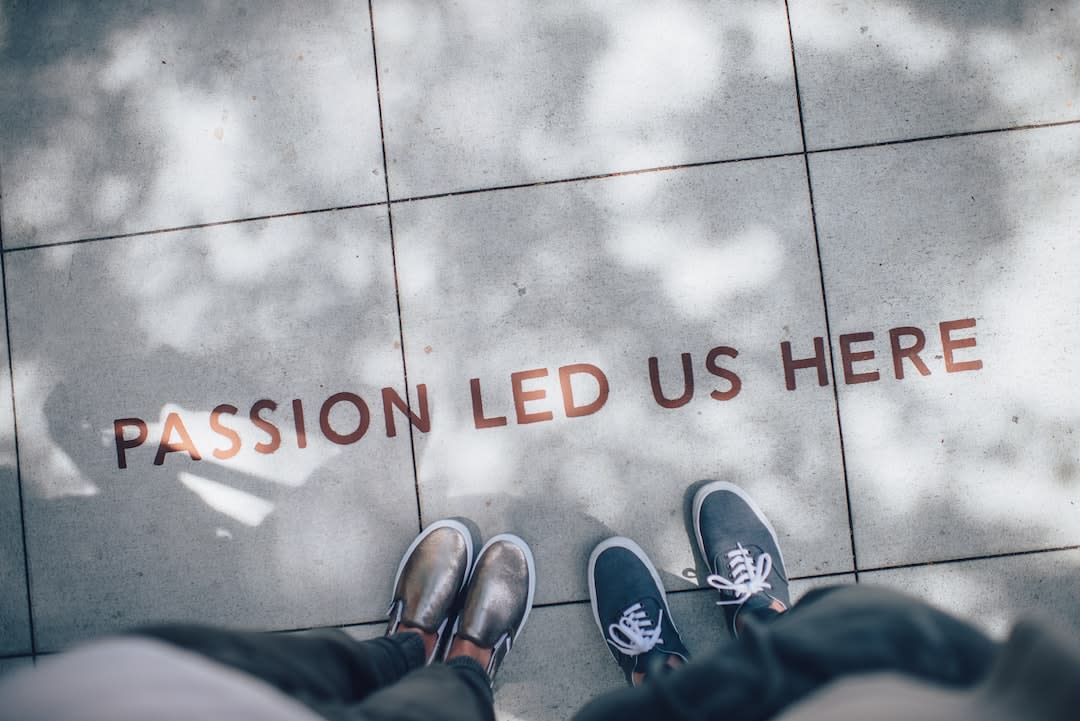 photo of individuals feet on a sidewalk with the words "Passion led us here"