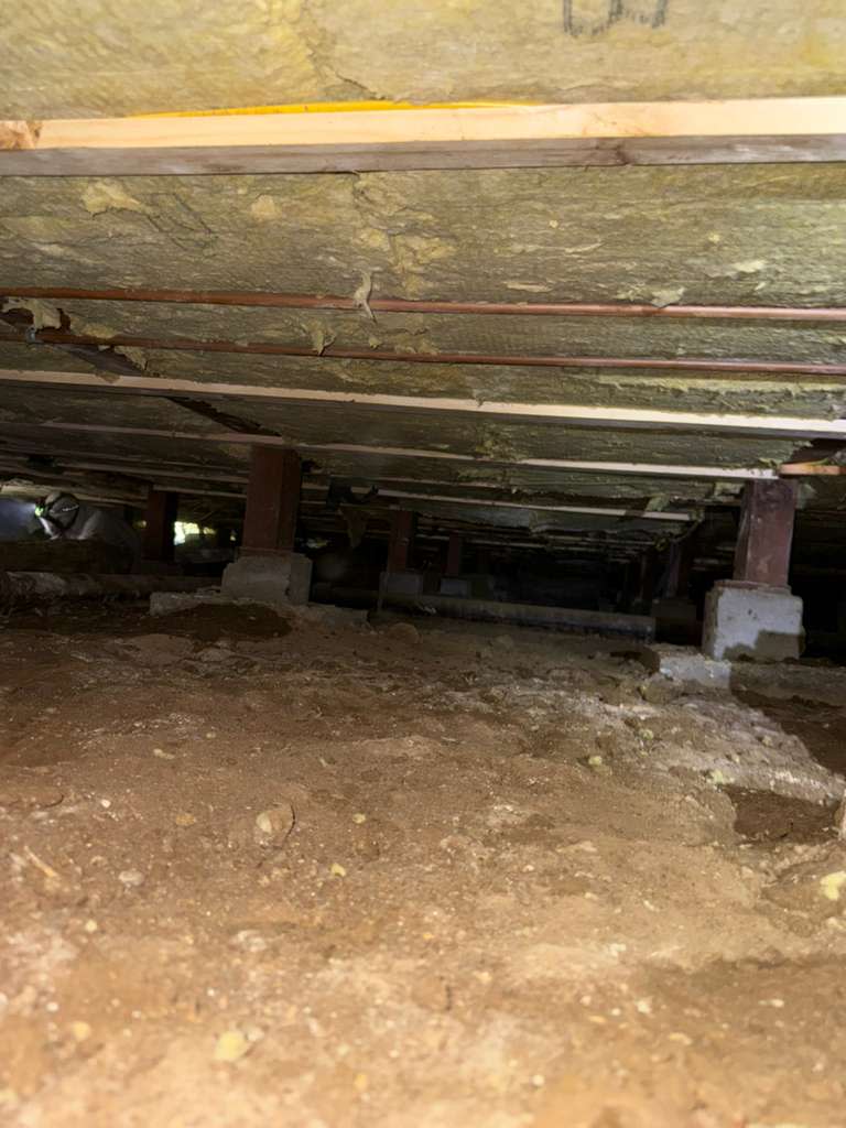 Installation of Rockwool insulation between crawl space floor joists for enhanced thermal and fire-resistant performance.