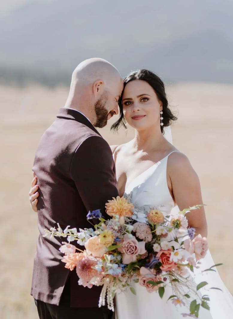 Bride and groom with colorful bouquet.