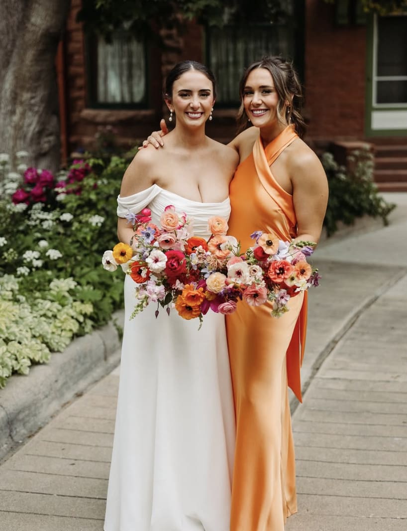 Bride and her bridesmaid holding their bouquets.