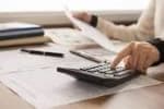 Paperwork, calculator being used possibly by an accountant