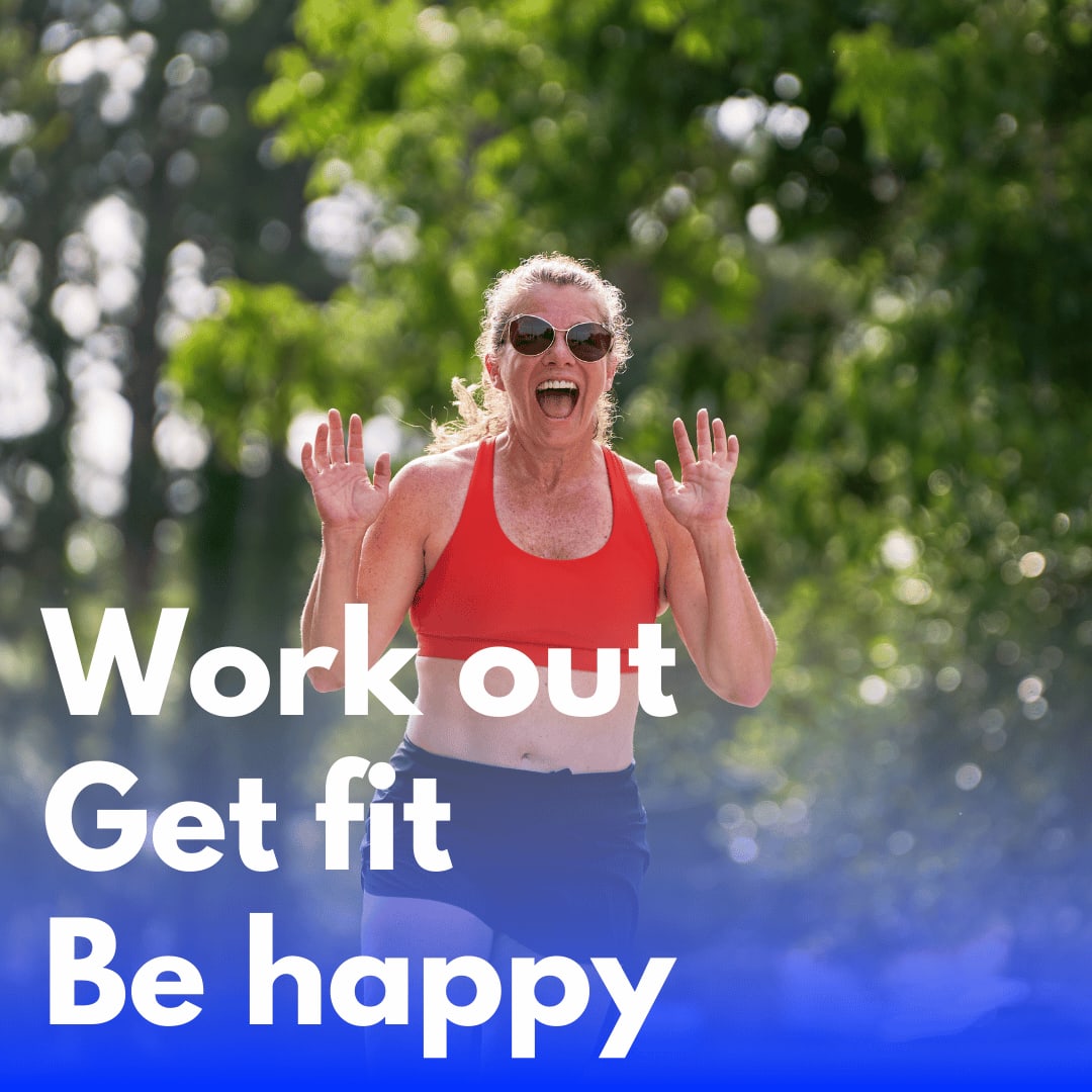 Smiling woman outdoors wearing a red sports bra and sunglasses, celebrating mid-run with her hands raised.