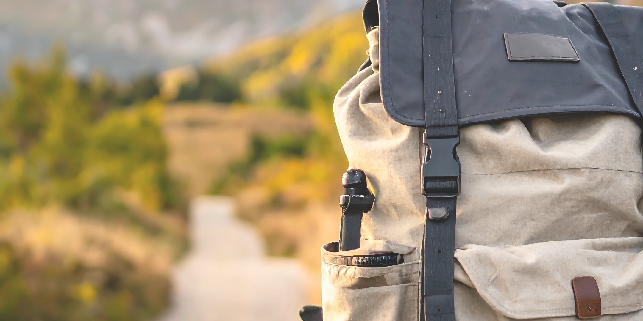 A backpack left on the side of a path forward into nature