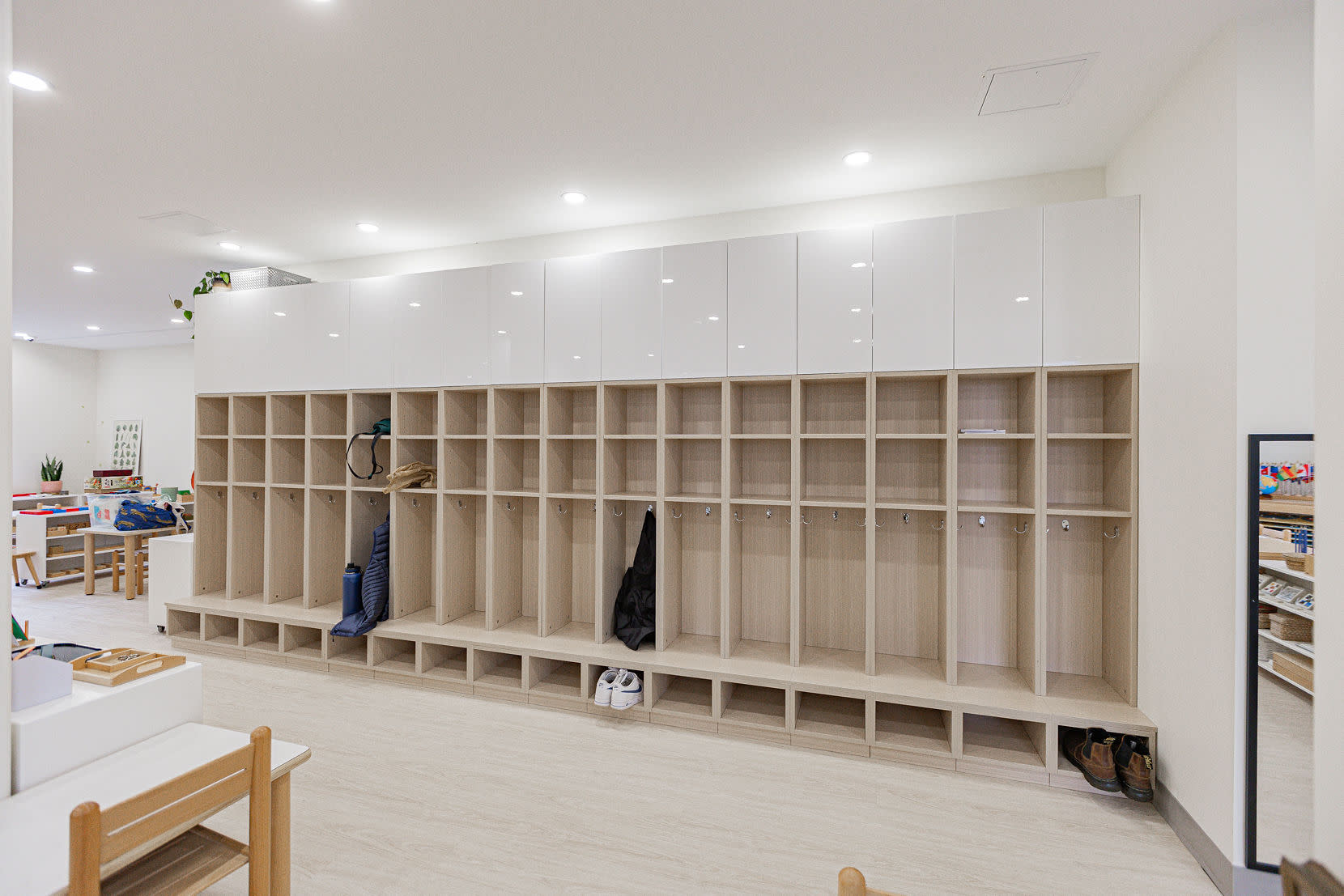 Premier Montessori Academy childcare interior at 6112 Sussex featuring custom built-in cubbies, upper storage cabinetry, ligh