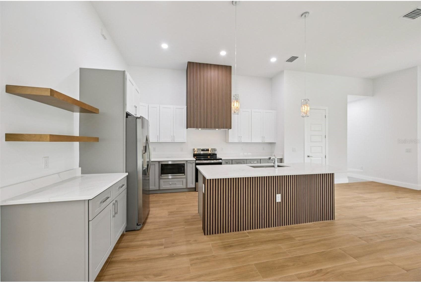 Completed modern kitchen and open living area by Sosnin Builders in Port Charlotte, Florida