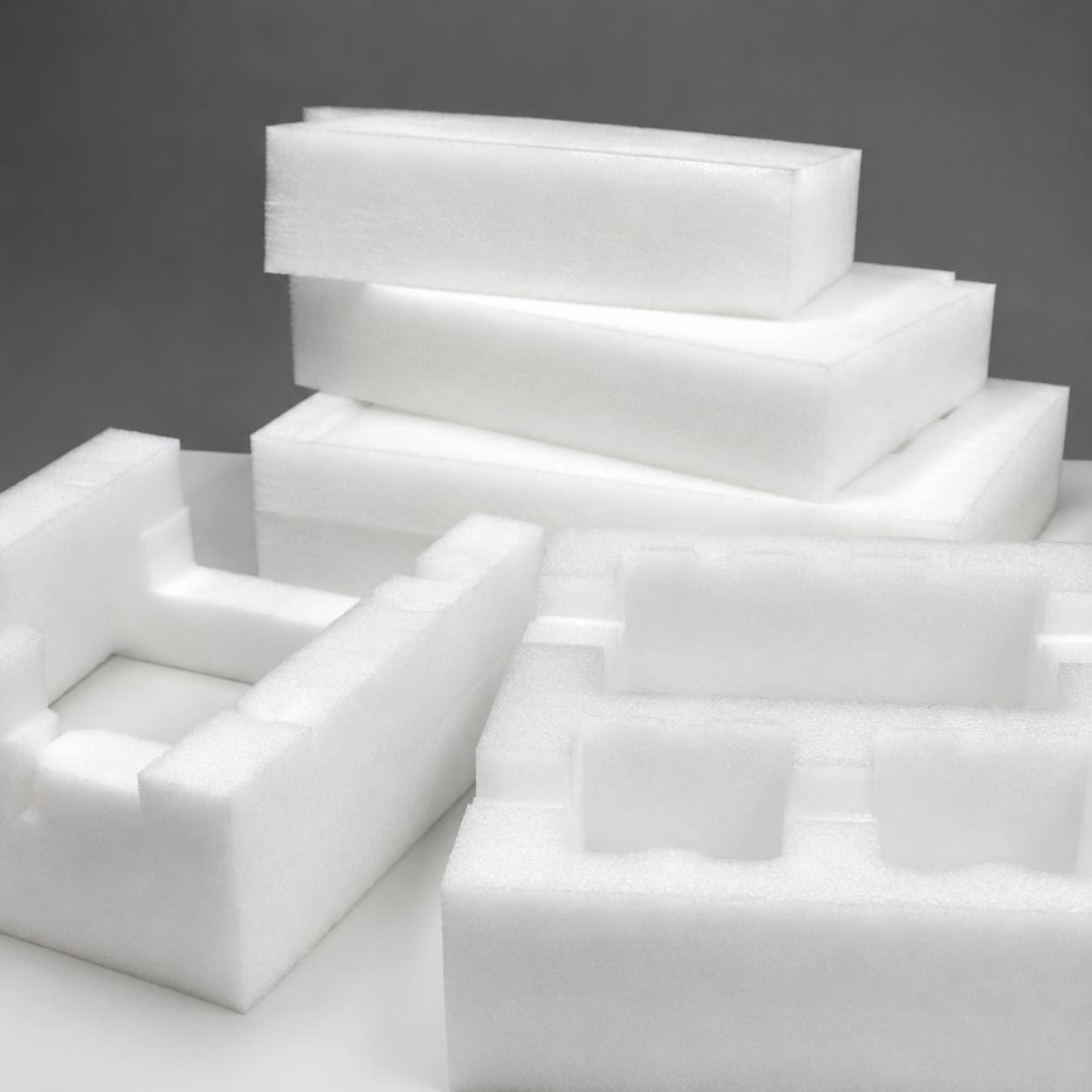 Custom white polyethylene foam inserts and end caps for protecting fragile industrial products during shipping.