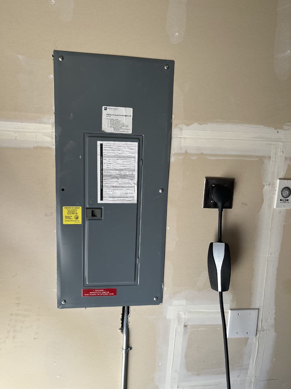 Electrical panel and EV charger installation by Surge Electrical in a residential garage.