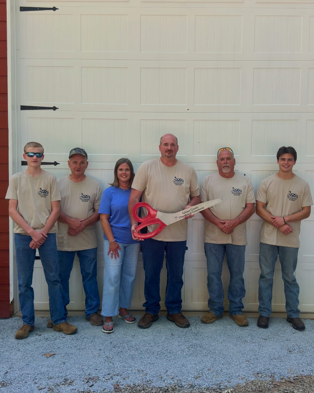 Carver Plumbing of North Ga, LLC team members standing together outside the company shop during a ribbon-cutting celebration.