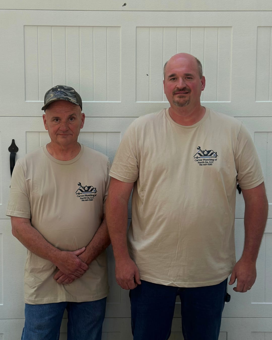 Jonathan Carver standing with his father, Neal Carver, outside the Carver Plumbing shop.