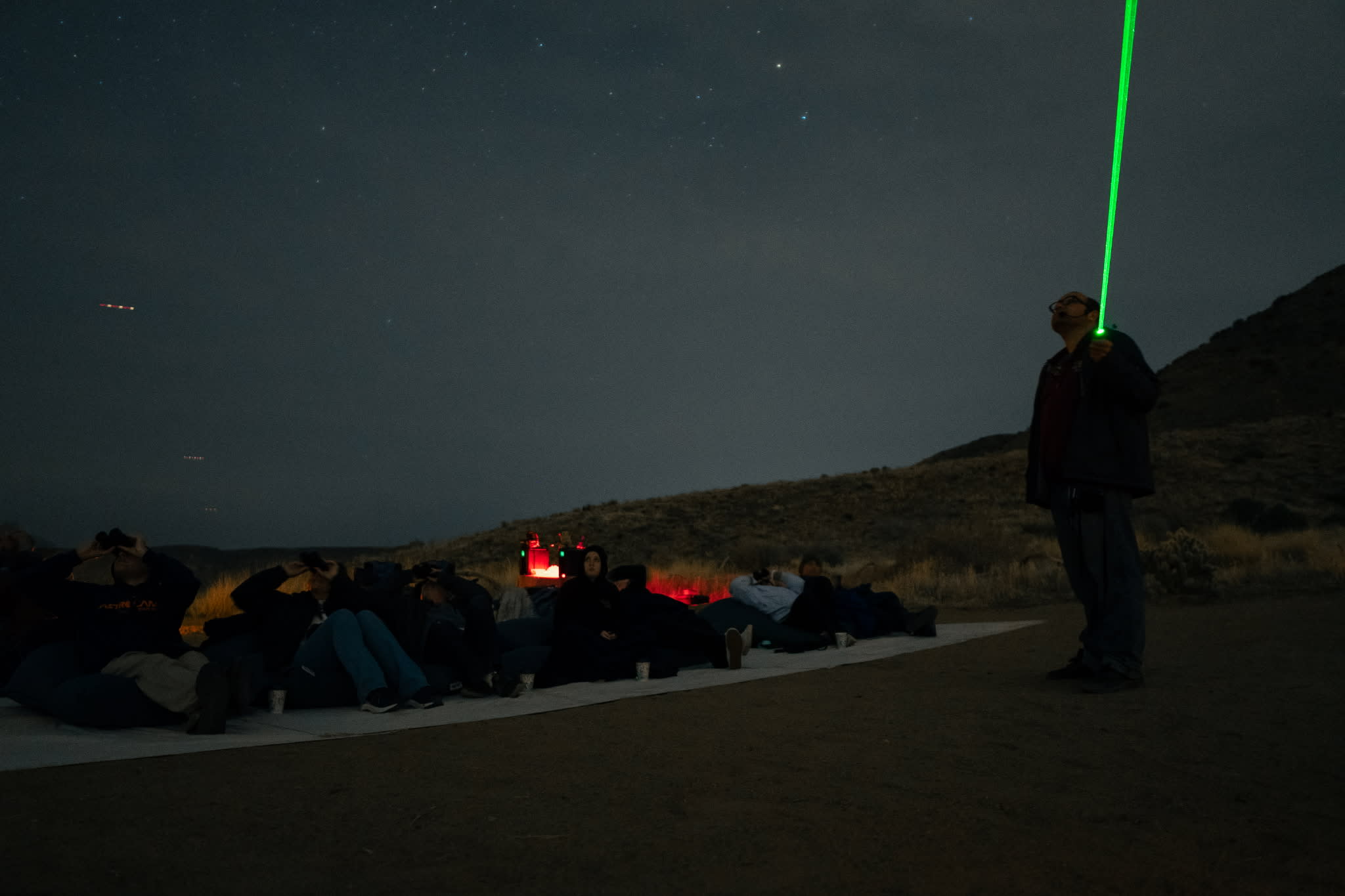 A stargazing tour. The guide points out objects in the sky with a laser pointer.