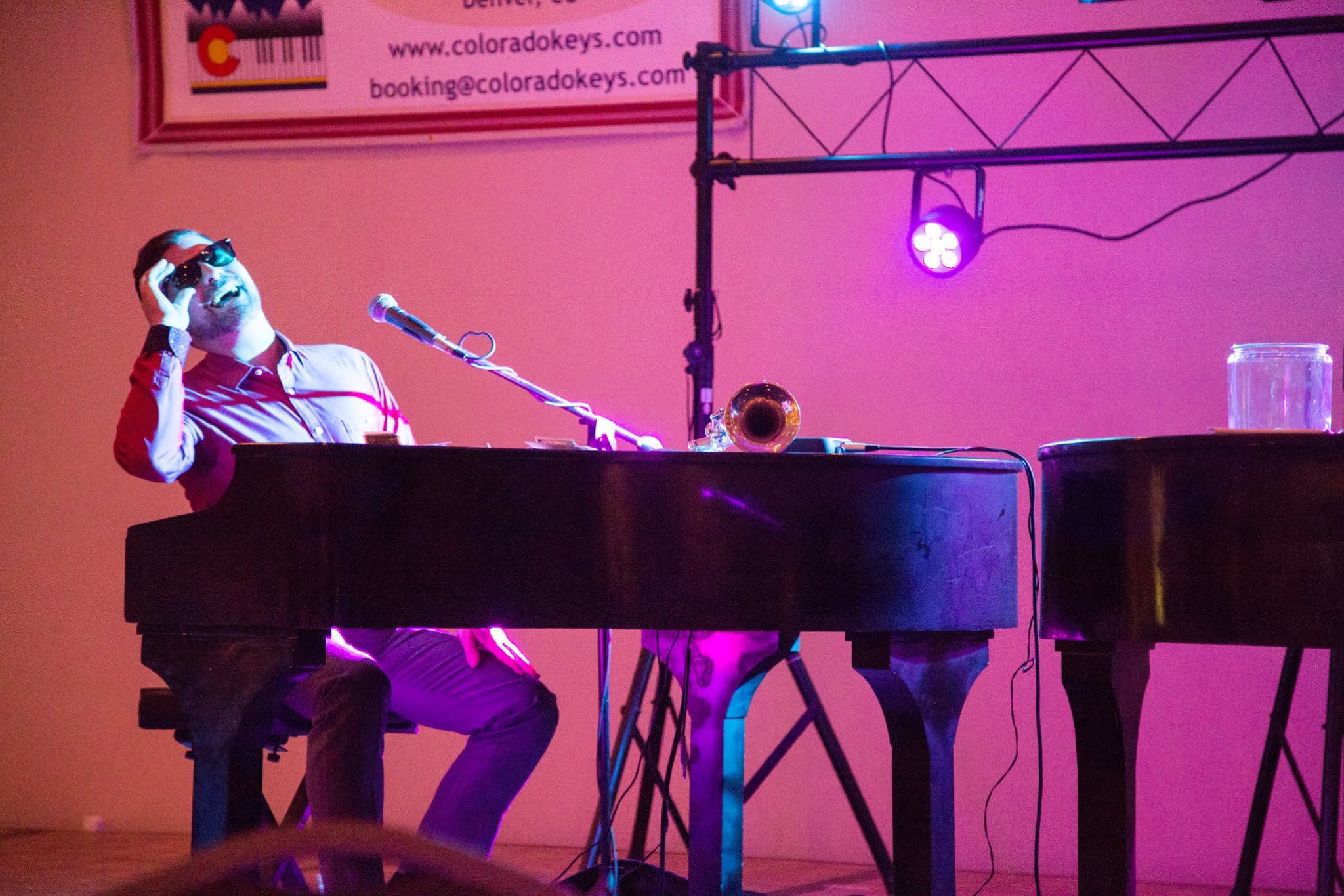 piano player sitting at the piano wearing sunglasses
