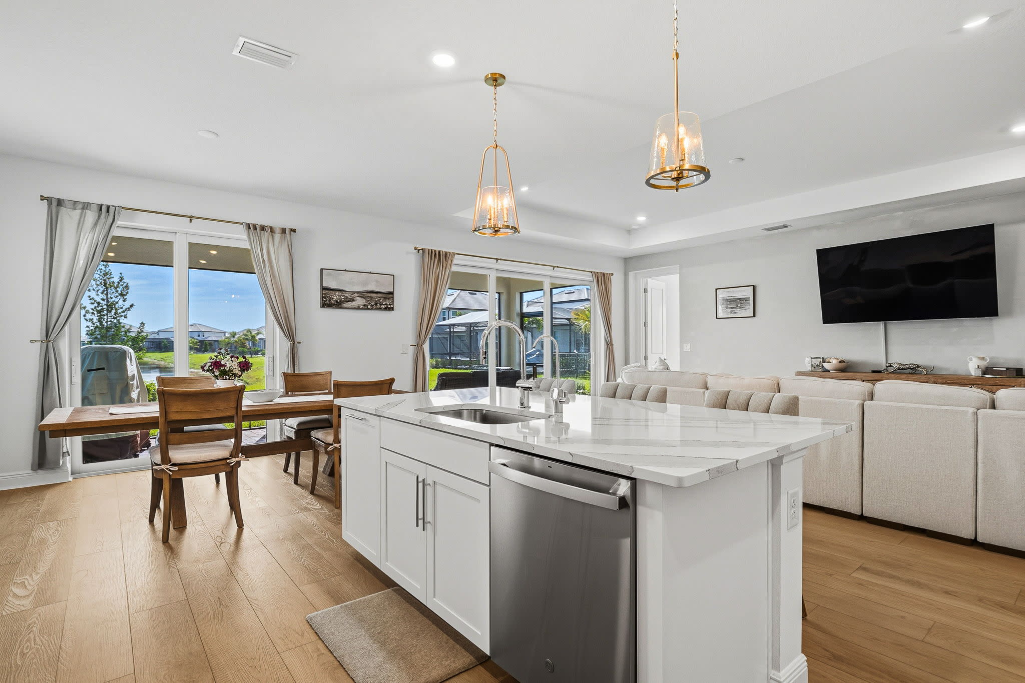 Professional real estate photography of an open-concept kitchen, dining, and living area in Sarasota, Florida by Bird Real Es
