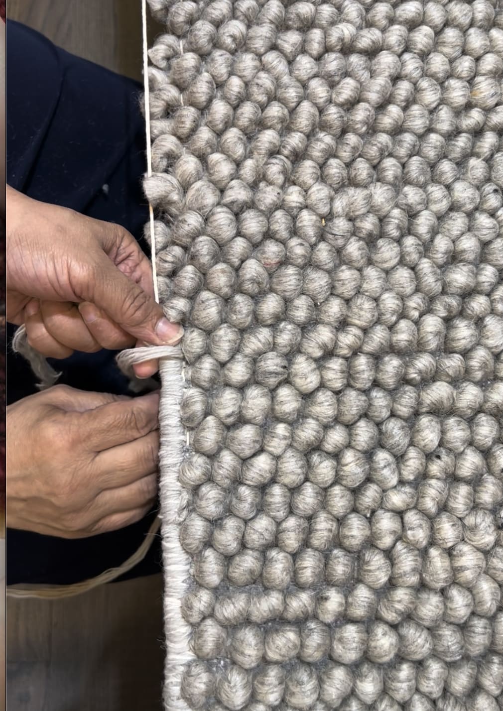 Hand binding and resizing a gray handwoven wool rug
