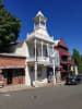 Main Street Antiques & Books store front view with Firehouse Museum No 1 next door with white steeple and balconies