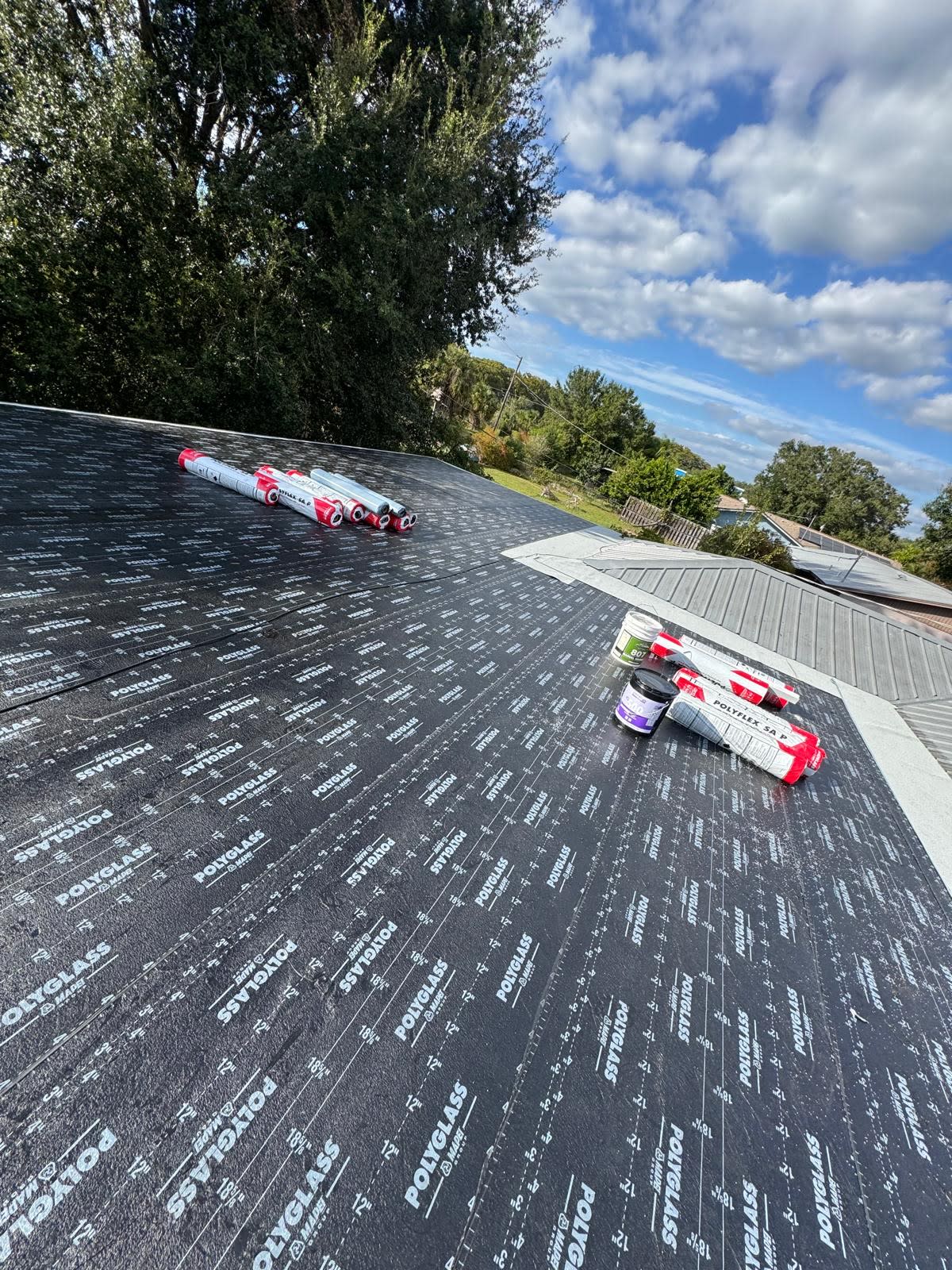 Licensed Mighty Fine Roofing crew installing flat roof underlayment during a commercial roofing project in Naples, Florida