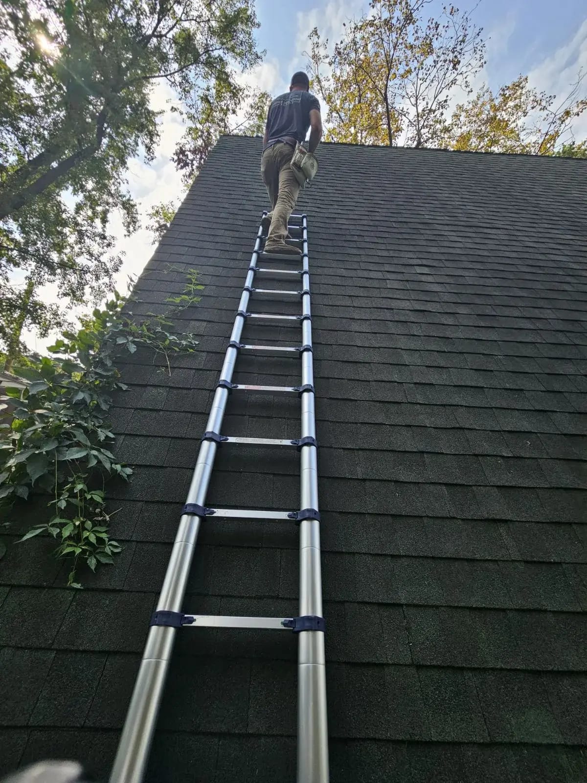 Roofing contractor climbing ladder for roof inspection in Central Minnesota residential home