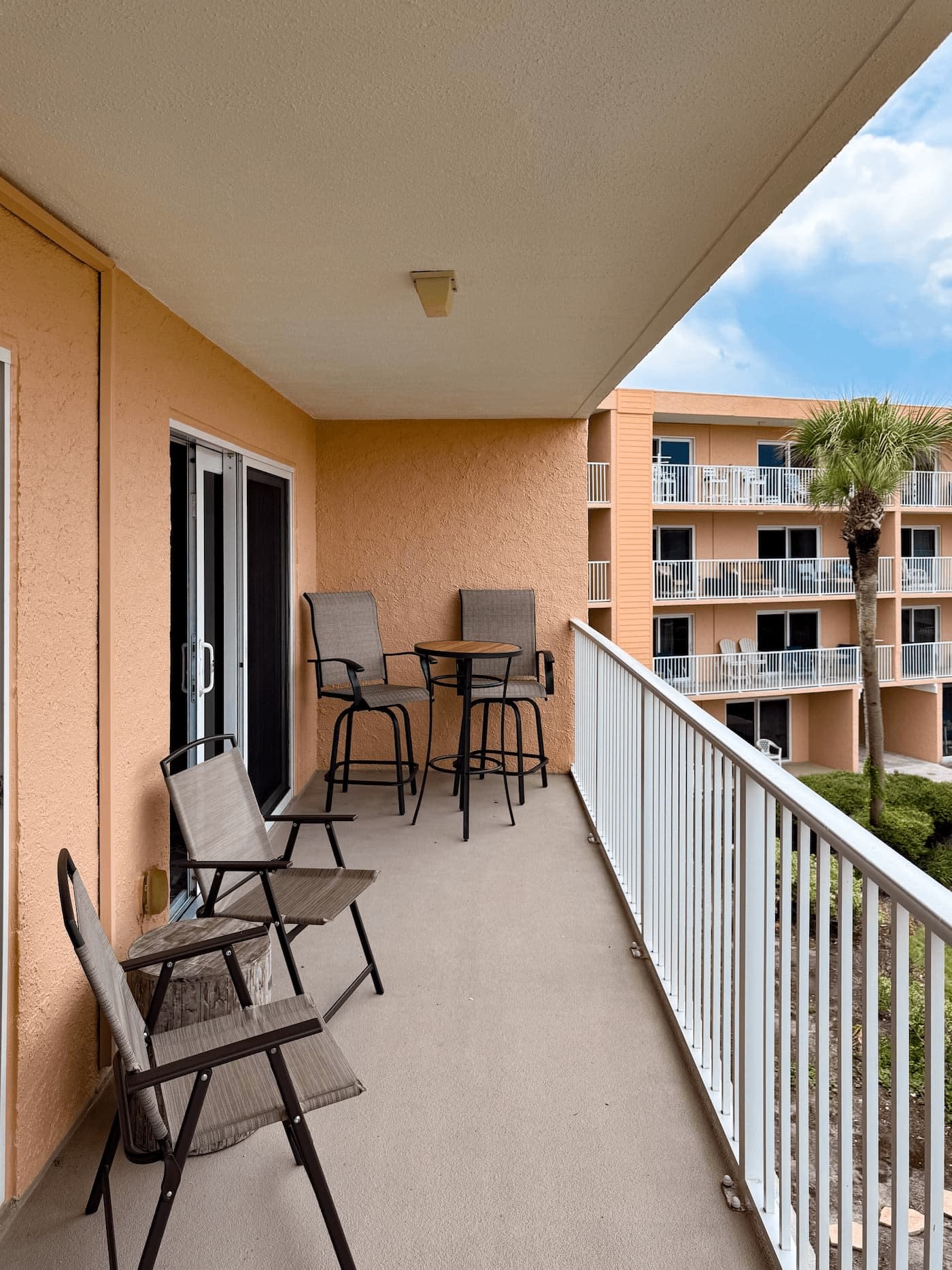 Private ocean-view balcony with chairs and a table at Coastal Dreams.