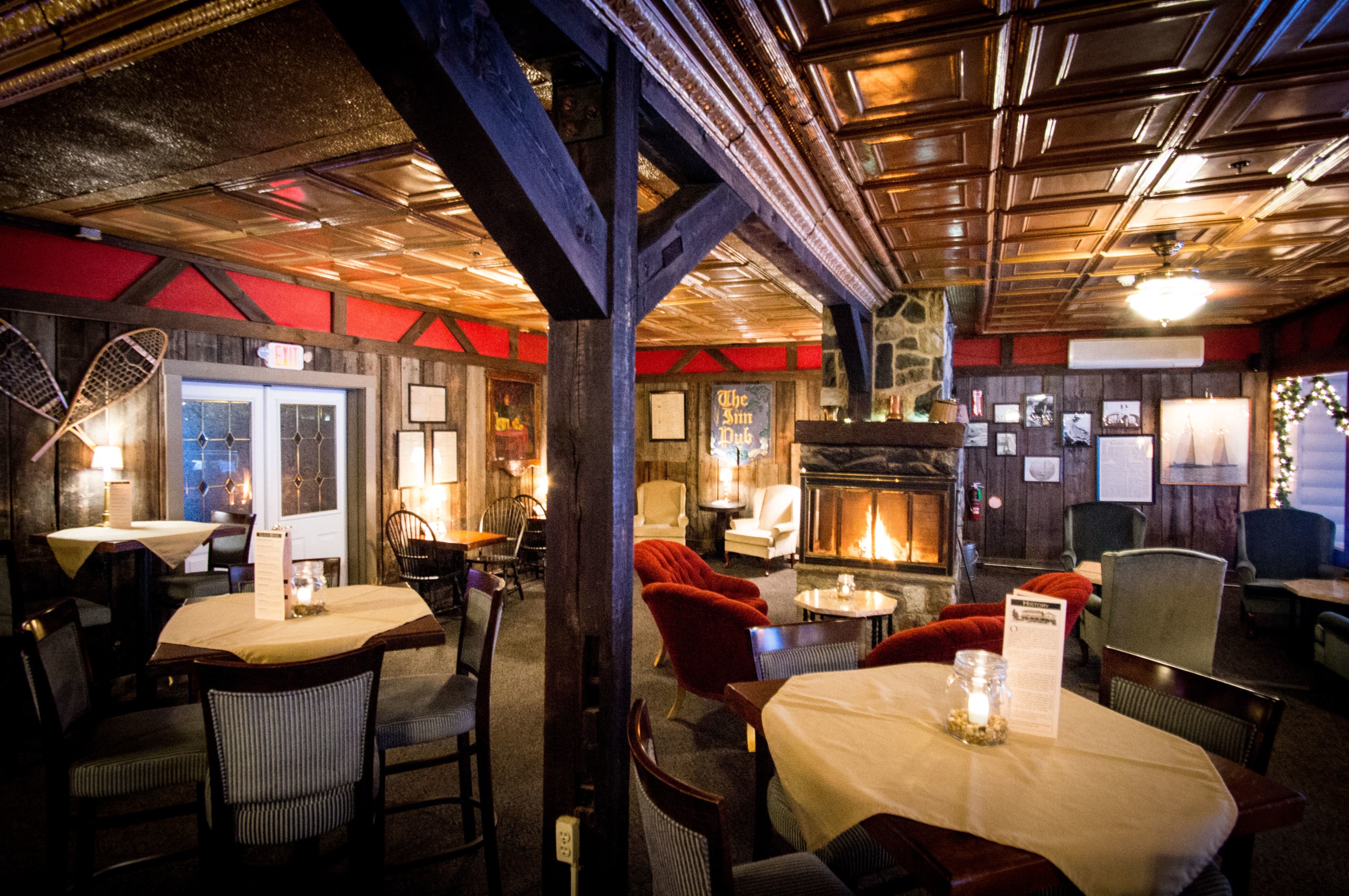 Image of the Rangeley Tavern with dining tables and fireplace.