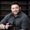 Cape Cod photographer Jason Goldstein smiling and holding a camera.