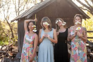 Women in beautiful dresses of Field Day Apparal- with flowers in front of a rustic barn