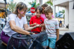 A woman holds a butterfly for children to observe