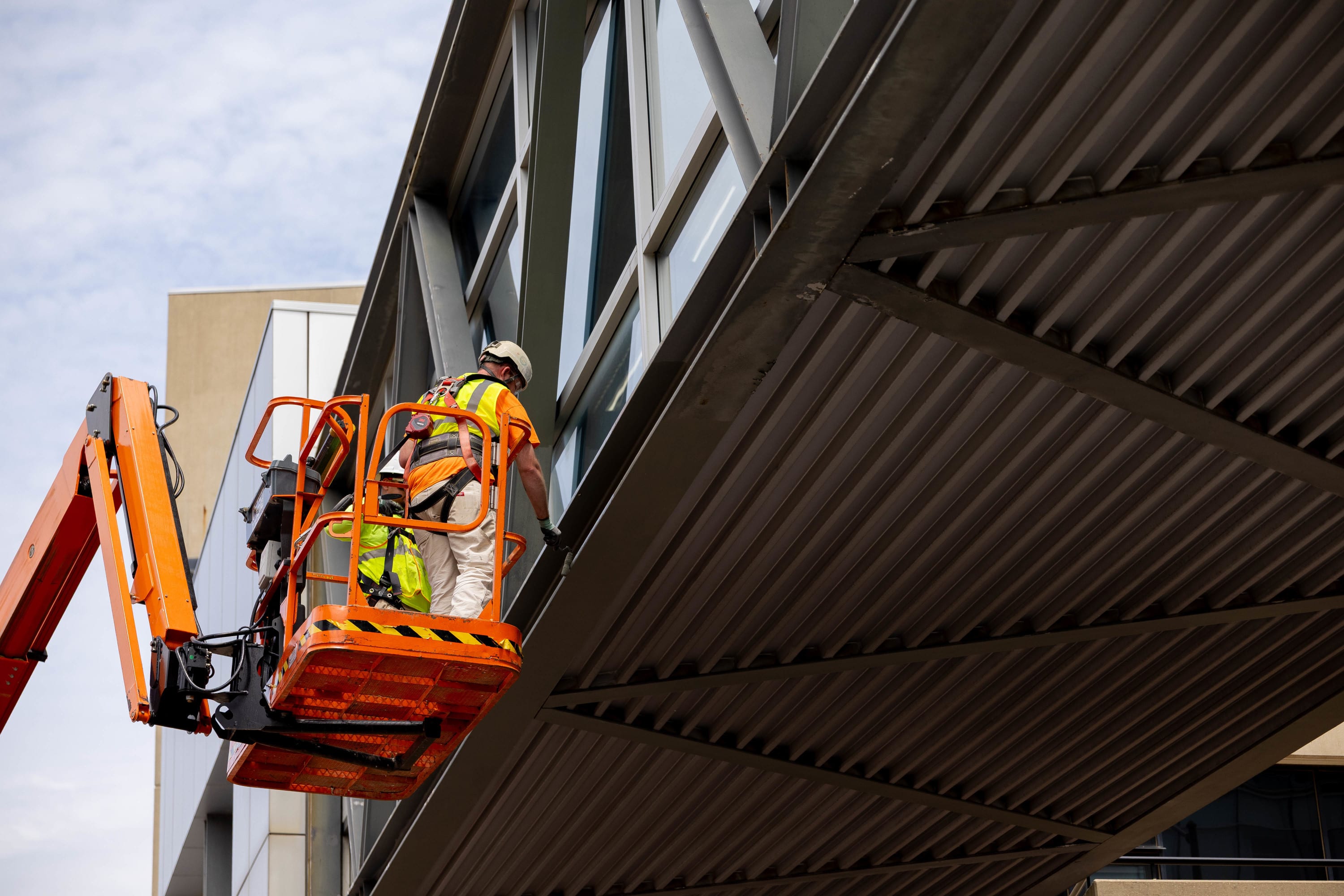 Men in a lift working on a skywalk