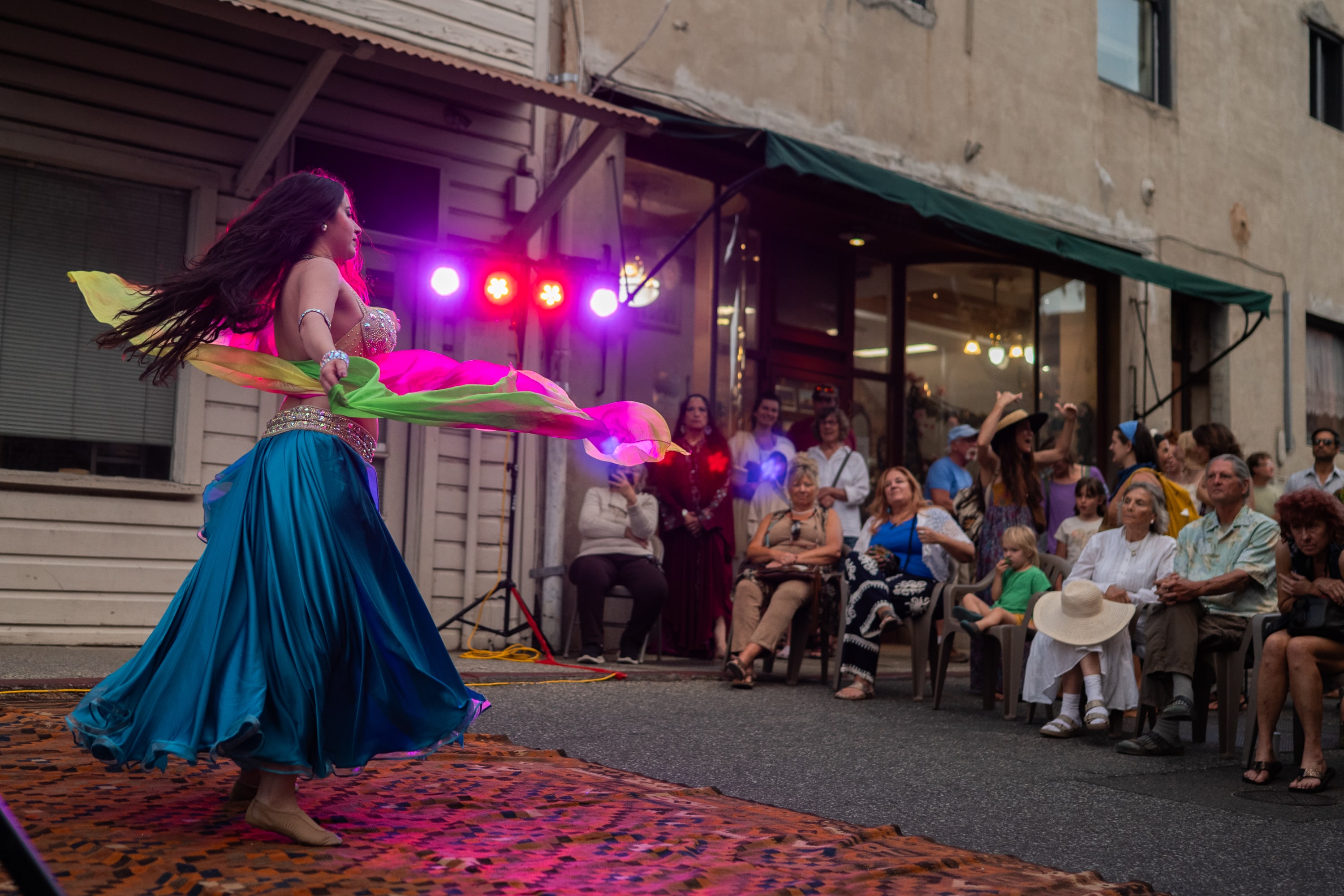 belly dancer with fabric in mid air before a crowd at Nevada City's Hot Summer Nights