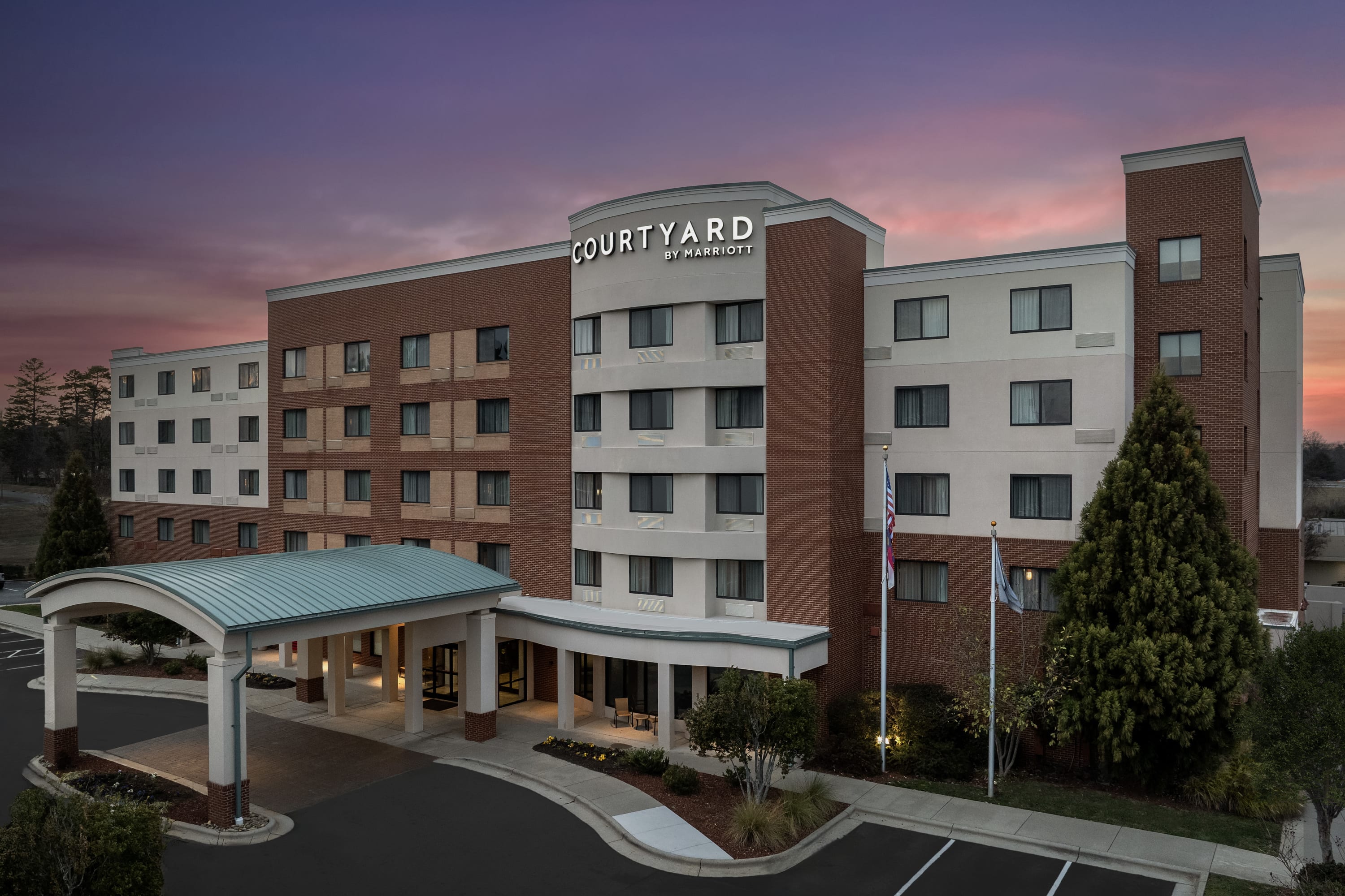 Full building shot of Courtyard Greensboro Airport with dusk sky