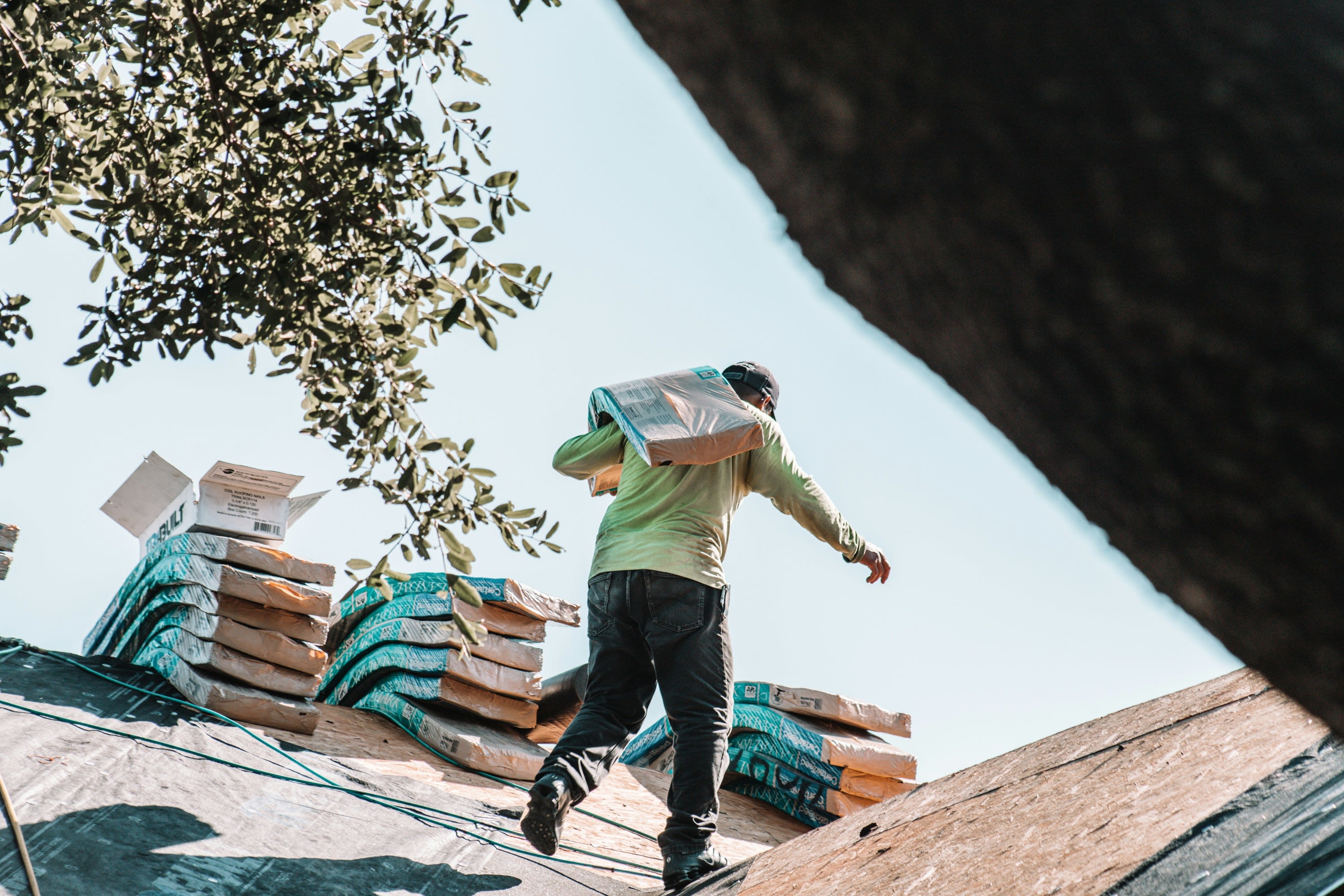 Photo of roofer carrying materials on the roof