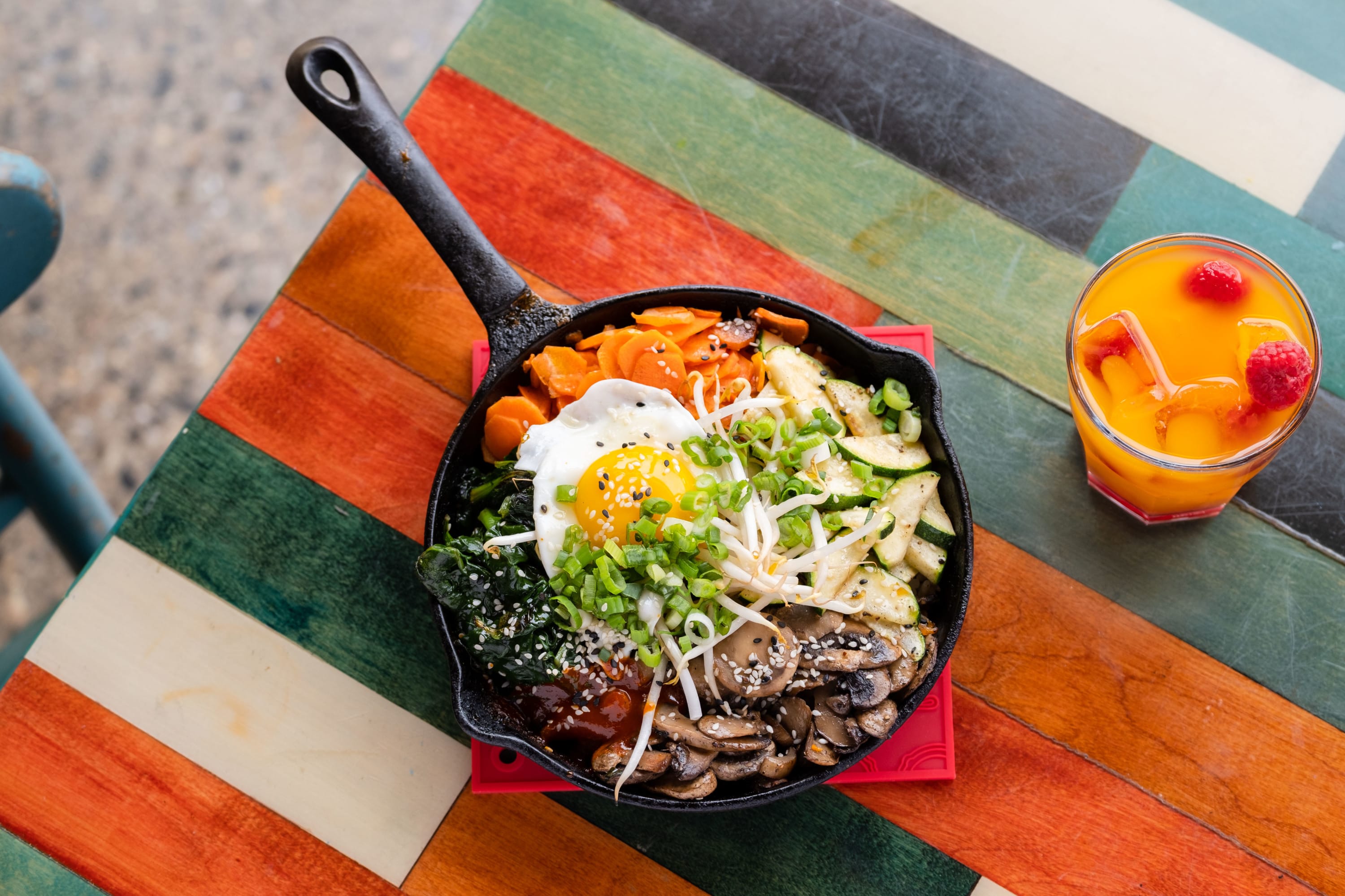 Bibimbap with sauteed vegetables and fried egg in a cast iron skillet