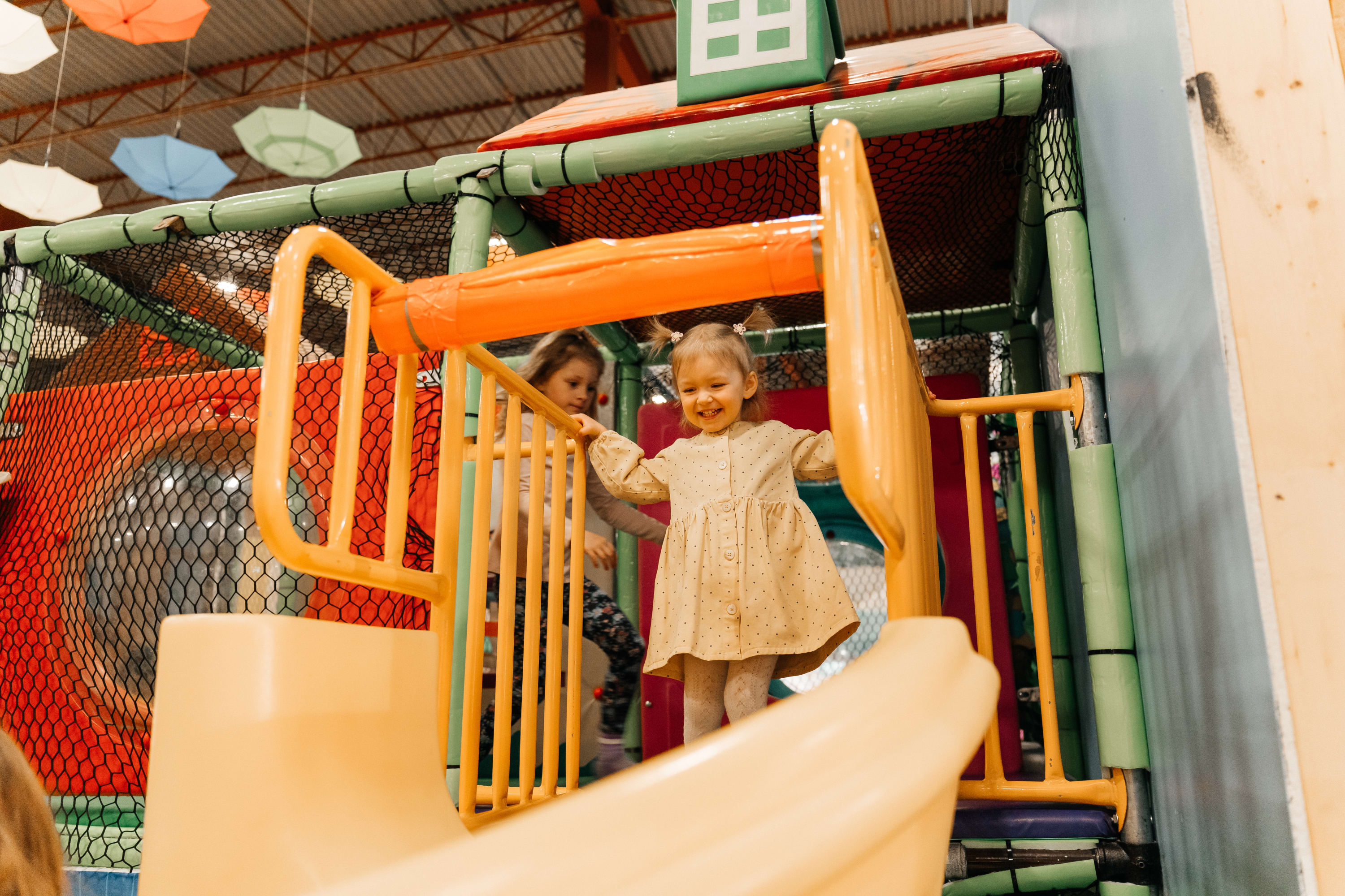 Children playing on an indoor play structure at Bountiful Farmers’ Market, highlighting its family-friendly environment