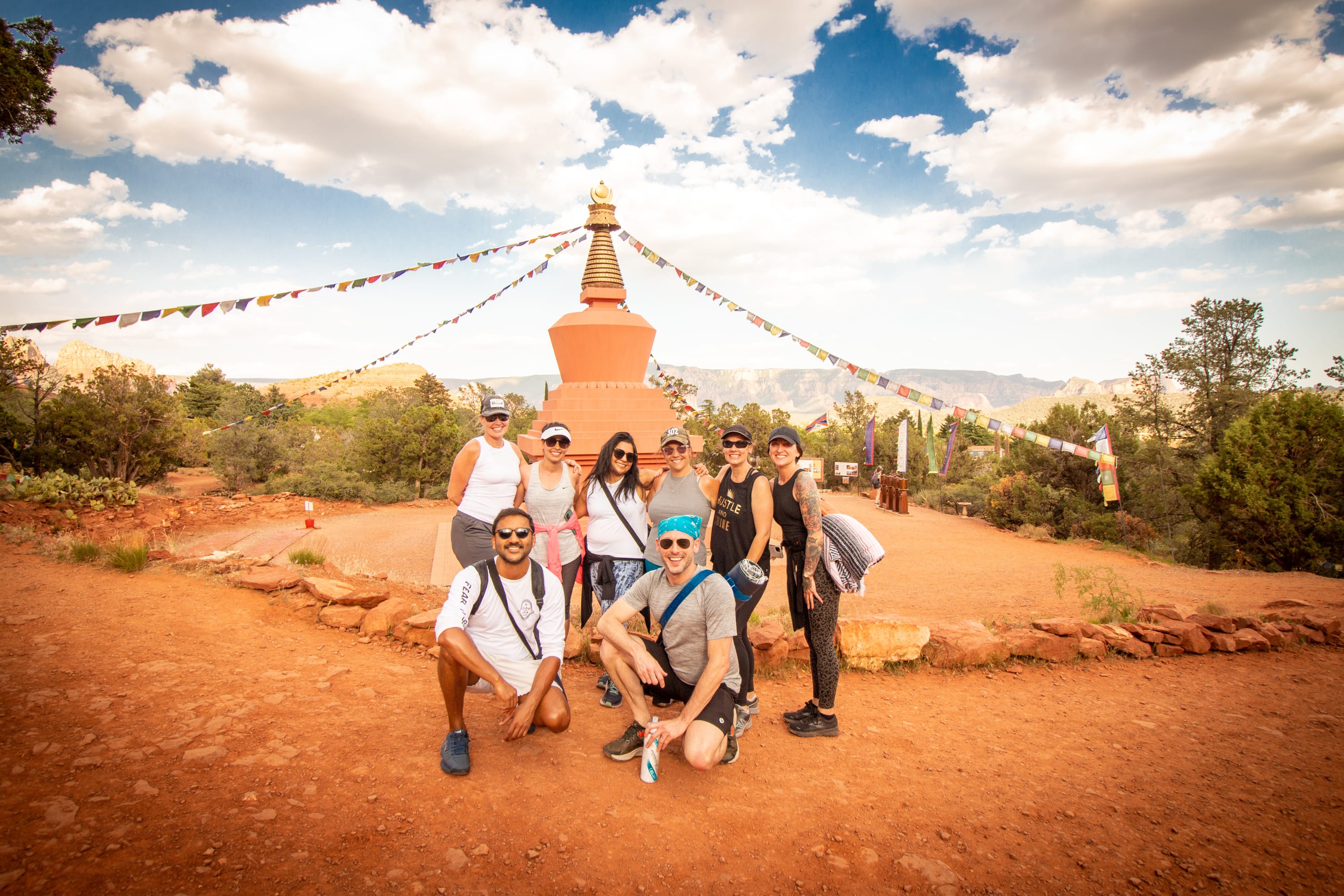 A happy group hiking and posing for a photo on a Sedona Yoga retreat with Vita Pura Yoga.