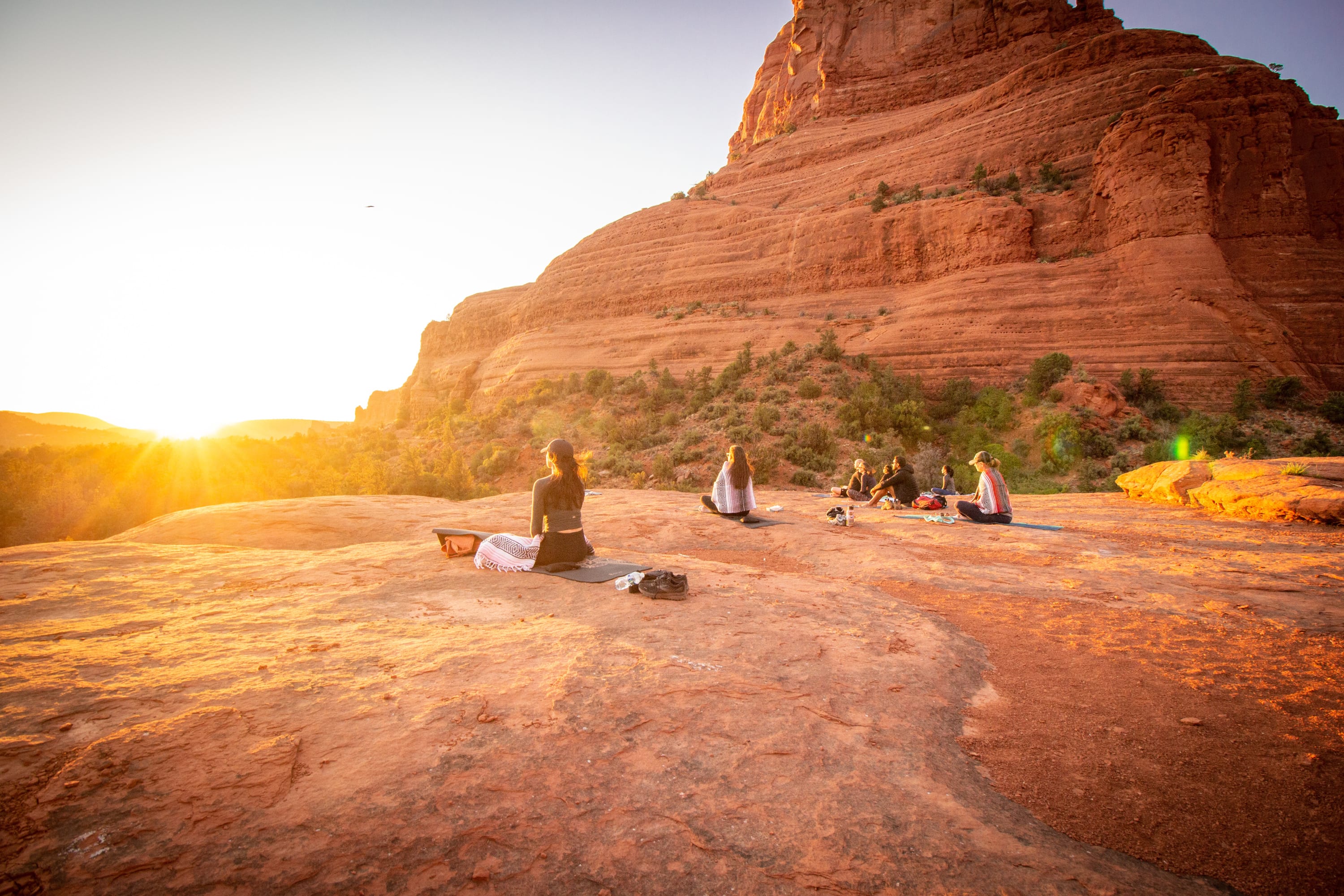 A group meditating in the Red Rocks during a yoga and hiking retreat in Sedona, Arizona.
