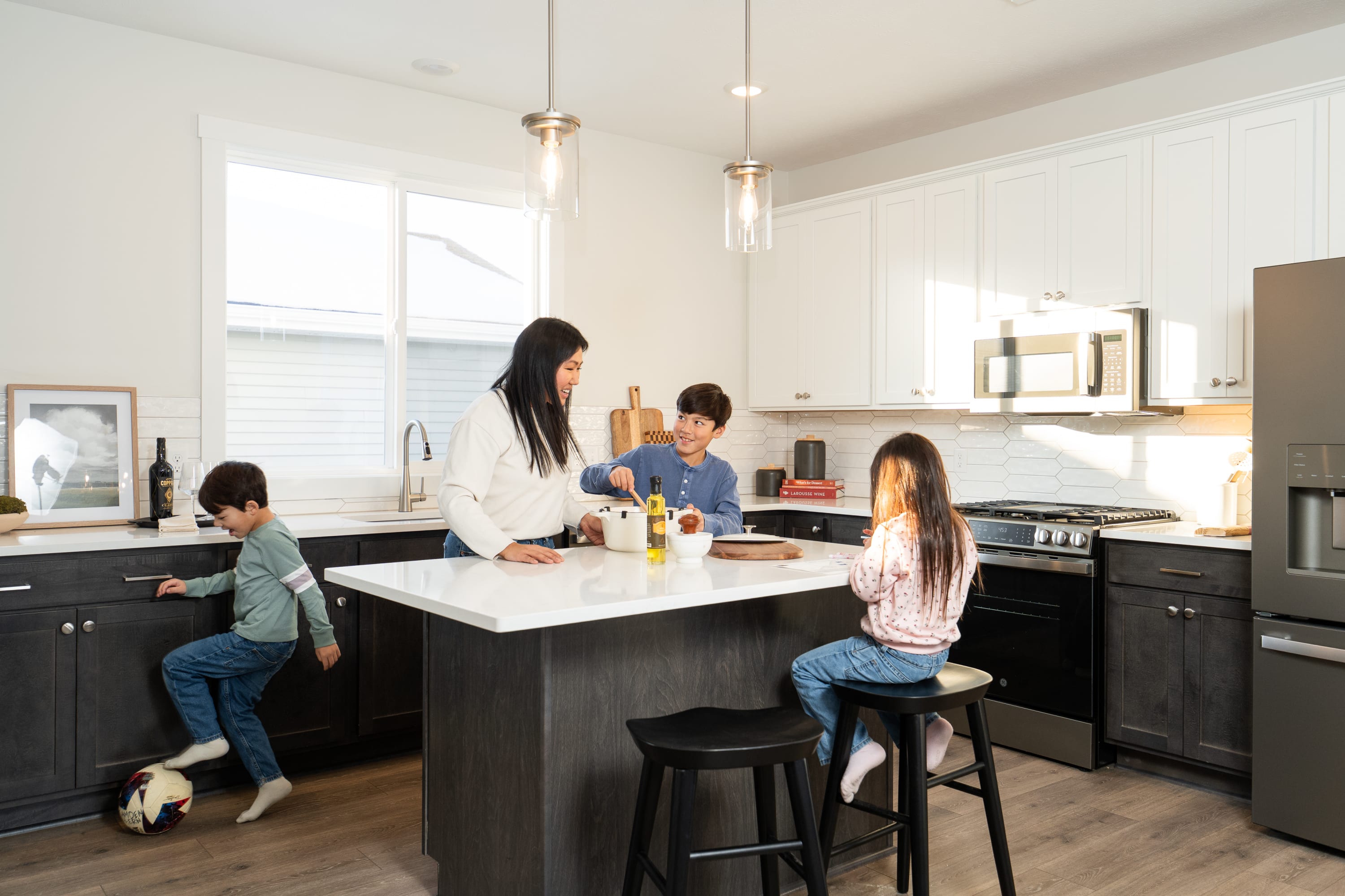 Family gathered around a kitchen island in an Interra Homes townhome.