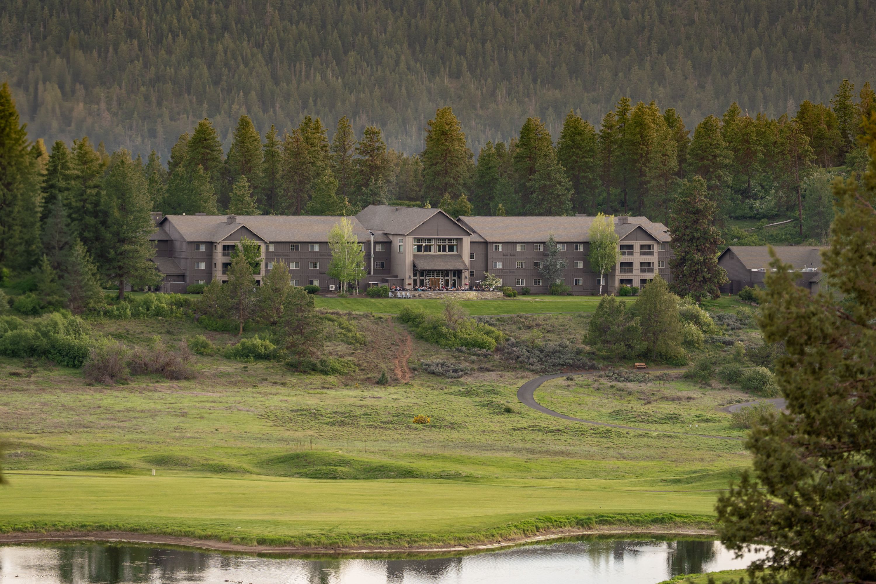 Wide view of Running Y Resort overlooking a golf course, water feature, and forested hills in Klamath Falls, Oregon