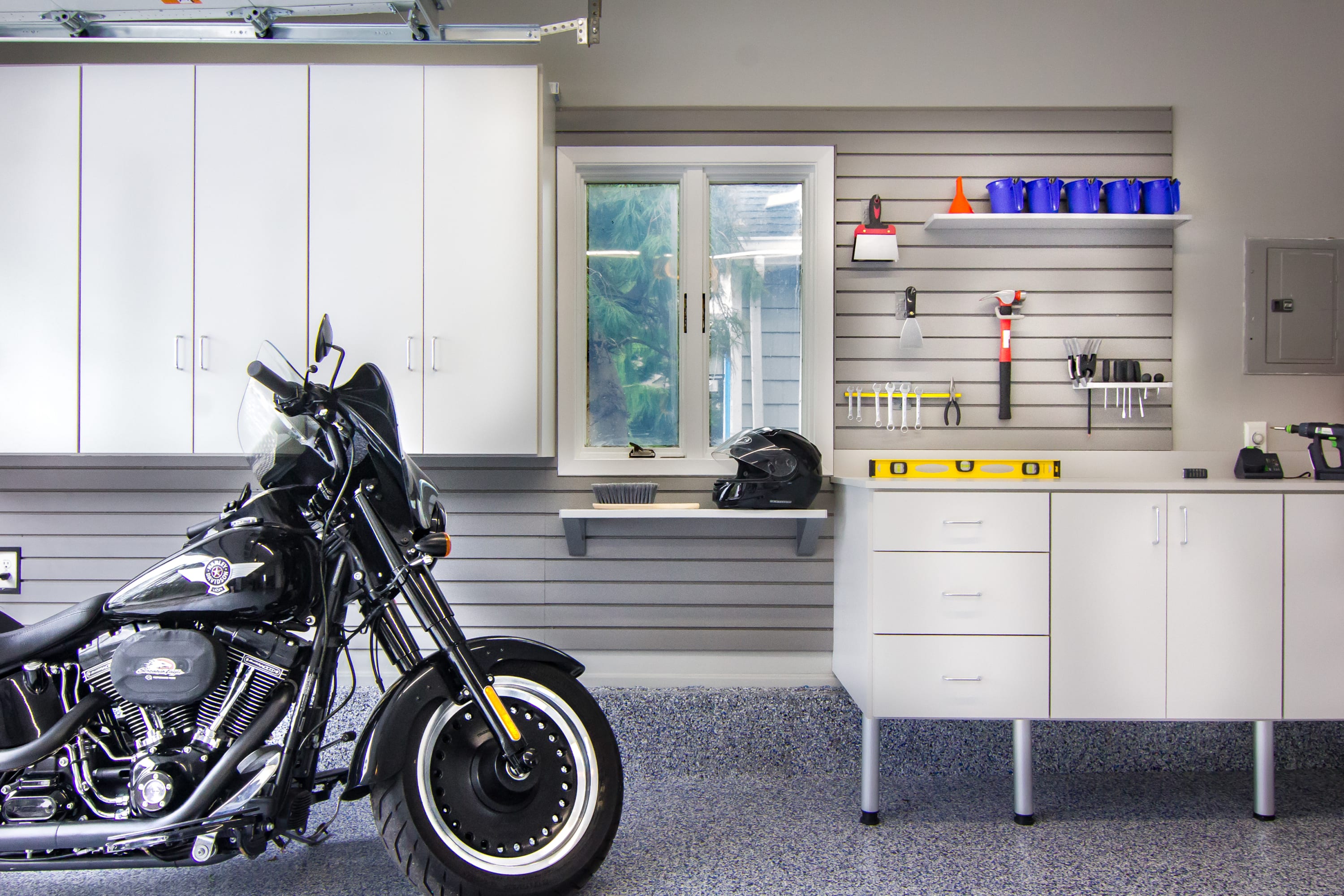 Custom Garage with slat wall storage, cabinets and motorcycle