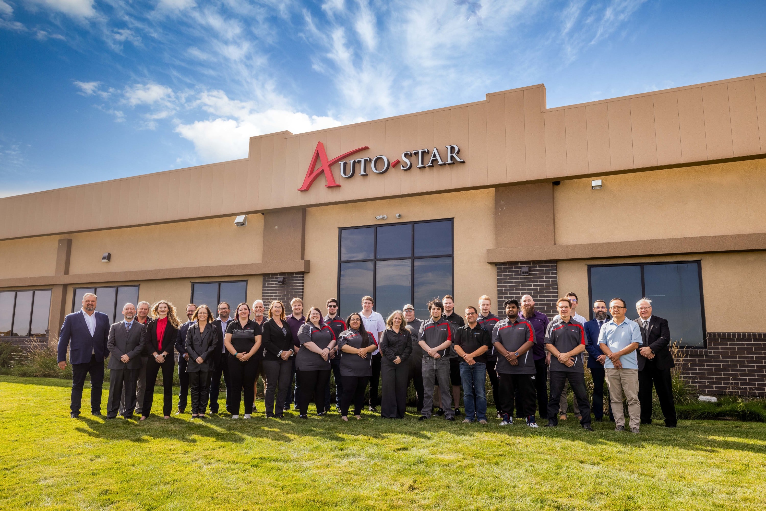 Auto-Star team members standing outside the Auto-Star head Office building in a group photo.