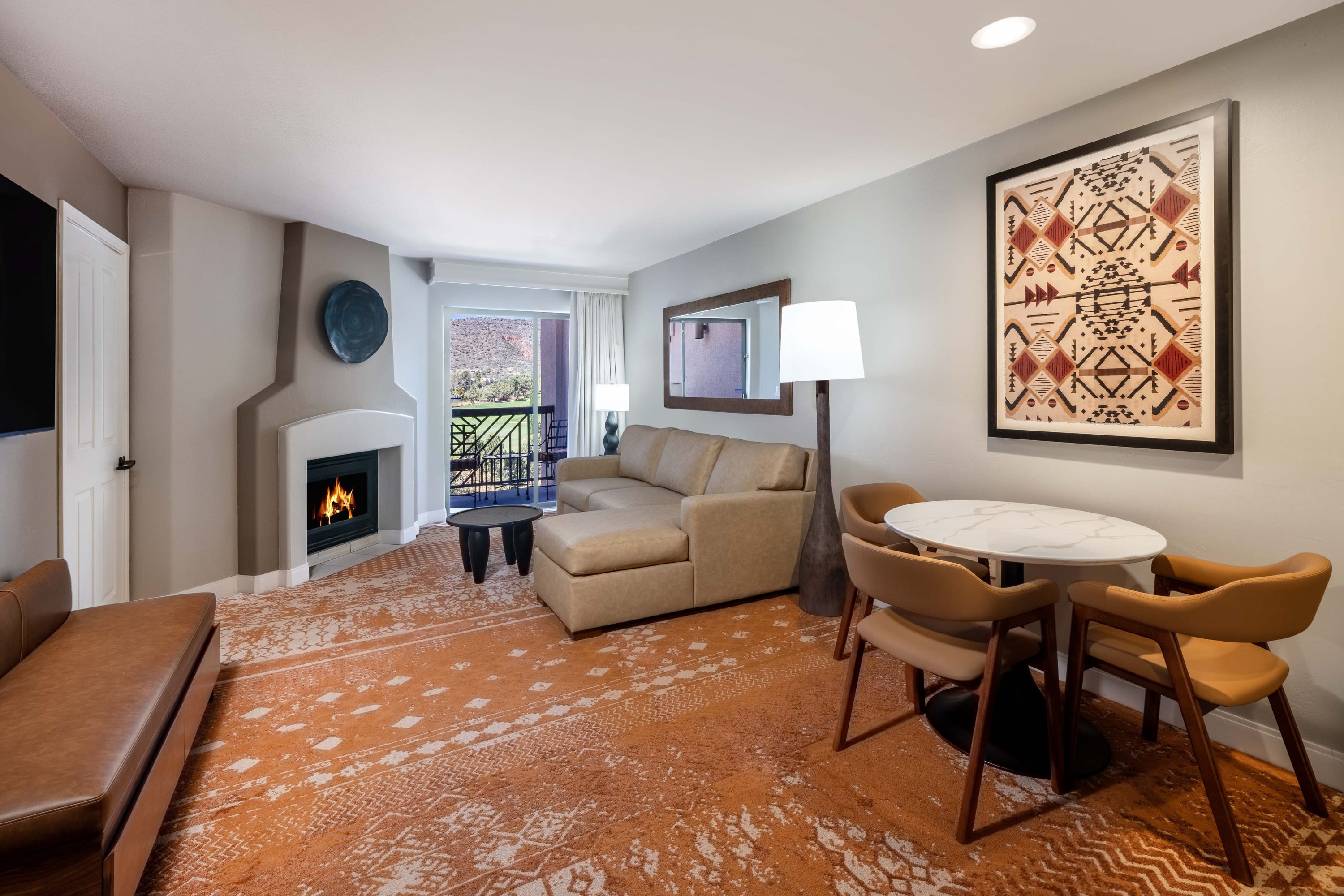 Bright and spacious suite featuring premium bedding, a sitting area, and fireplace